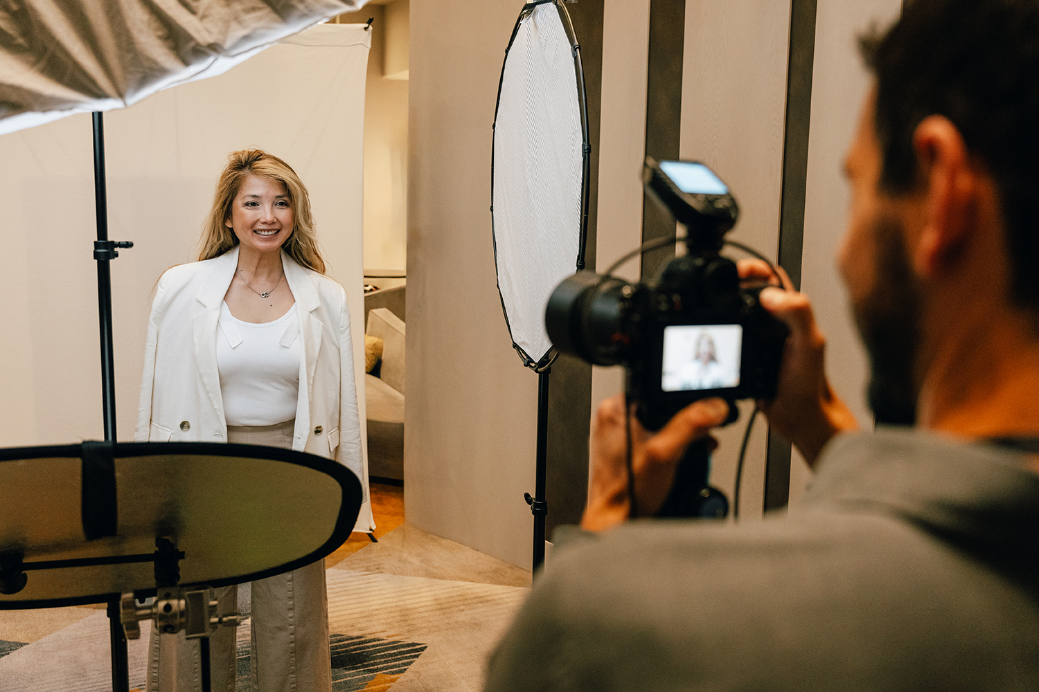 A photographer photographing a smiling attendee at a branded headshot booth